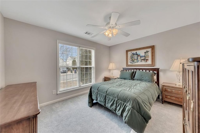 bedroom featuring light colored carpet, visible vents, ceiling fan, and baseboards