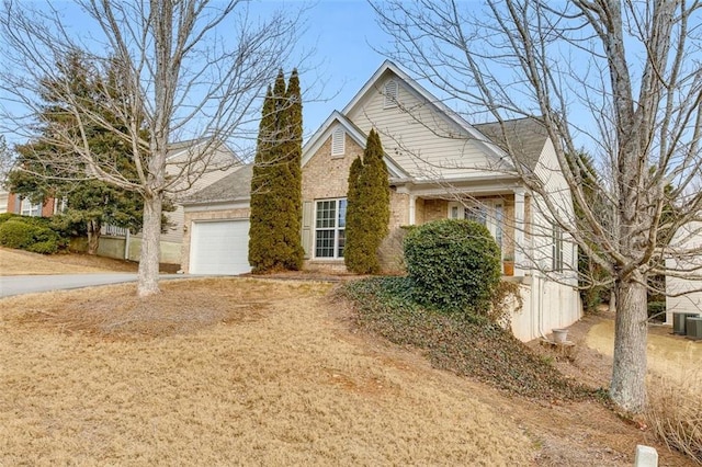 view of front of home with an attached garage, a chimney, concrete driveway, and brick siding