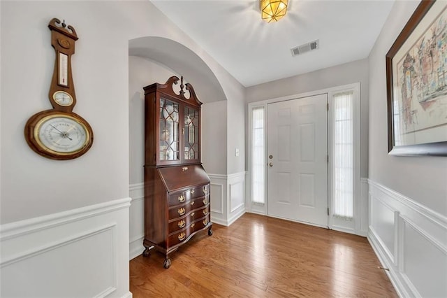 foyer with wainscoting, visible vents, and light wood-style floors