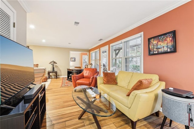 living room with crown molding and light hardwood / wood-style flooring