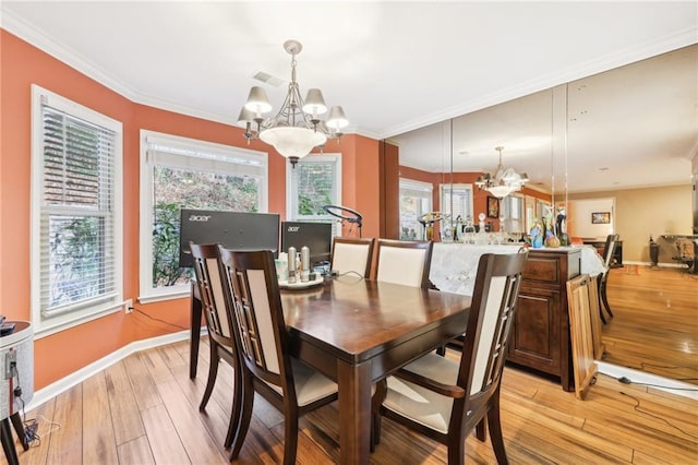 dining space featuring light hardwood / wood-style floors, an inviting chandelier, and crown molding