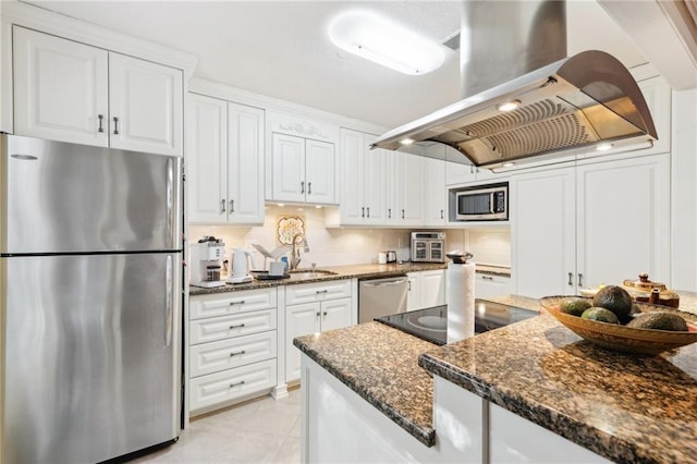 kitchen with white cabinets, sink, dark stone countertops, appliances with stainless steel finishes, and island exhaust hood