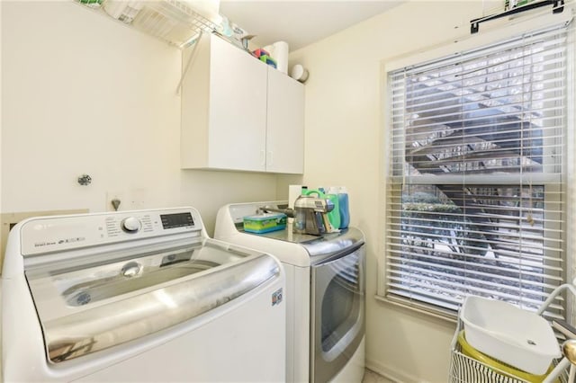 laundry area featuring washer and clothes dryer and cabinets