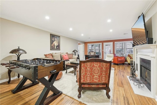 game room with light hardwood / wood-style flooring and ornamental molding