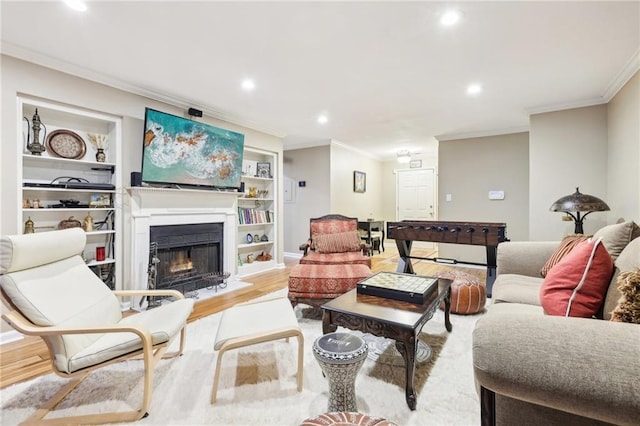 living room featuring light hardwood / wood-style floors, ornamental molding, and built in features