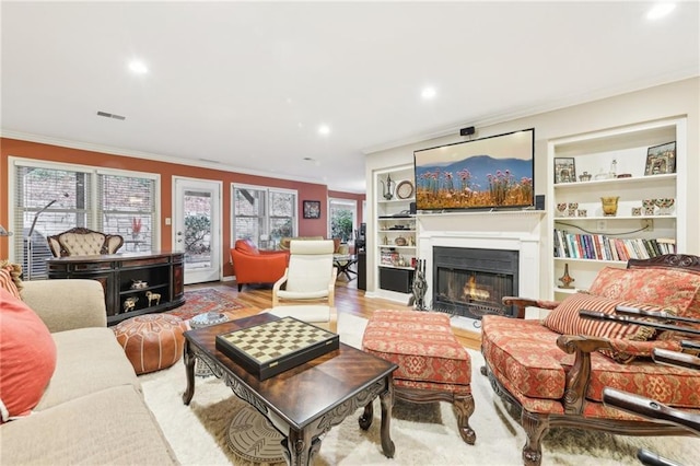 living room with light wood-type flooring and ornamental molding