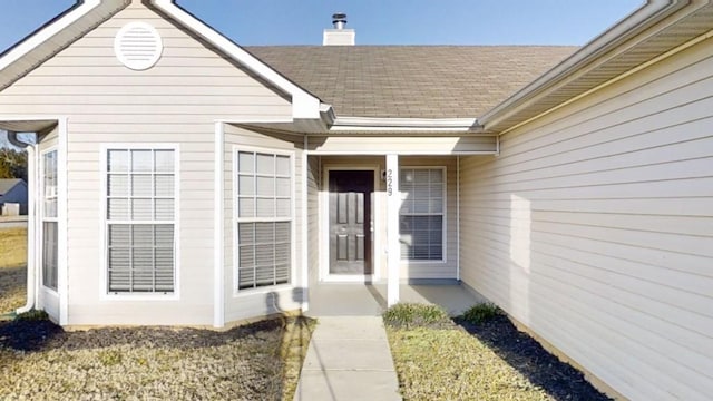 view of exterior entry with a yard