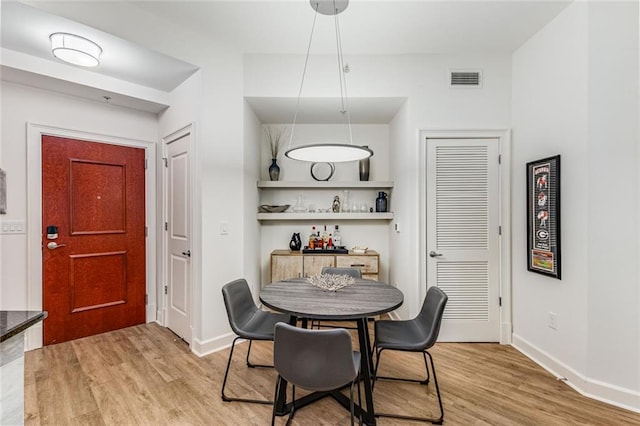 200 River Vista Dr Unit 713, Atlanta, GA 30339 - dining area featuring visible vents, light wood-style flooring, a dry bar, and baseboards