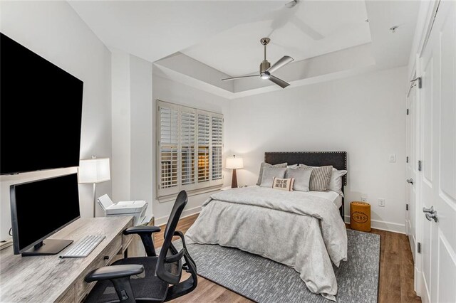200 River Vista Dr Unit 713, Atlanta, GA 30339 - bedroom with baseboards, a raised ceiling, ceiling fan, and wood finished floors
