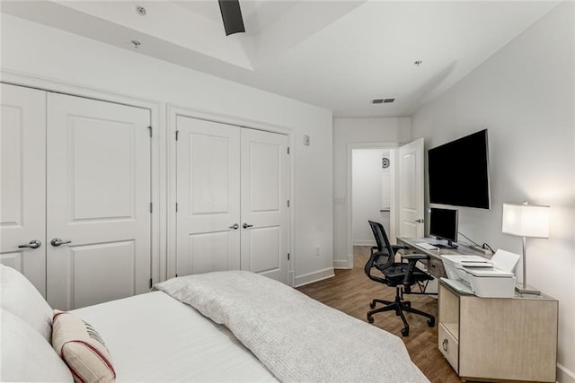 200 River Vista Dr Unit 713, Atlanta, GA 30339 - bedroom featuring baseboards, visible vents, multiple closets, ceiling fan, and wood finished floors