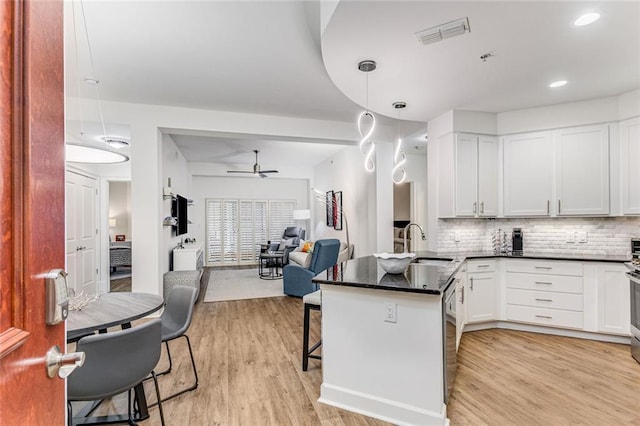 200 River Vista Dr Unit 713, Atlanta, GA 30339 - kitchen with visible vents, a sink, open floor plan, a ceiling fan, and a peninsula