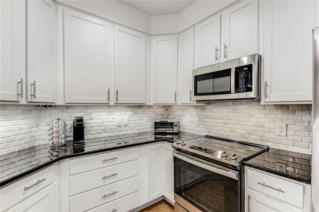 200 River Vista Dr Unit 713, Atlanta, GA 30339 - kitchen featuring dark stone countertops, decorative backsplash, white cabinets, and stainless steel appliances