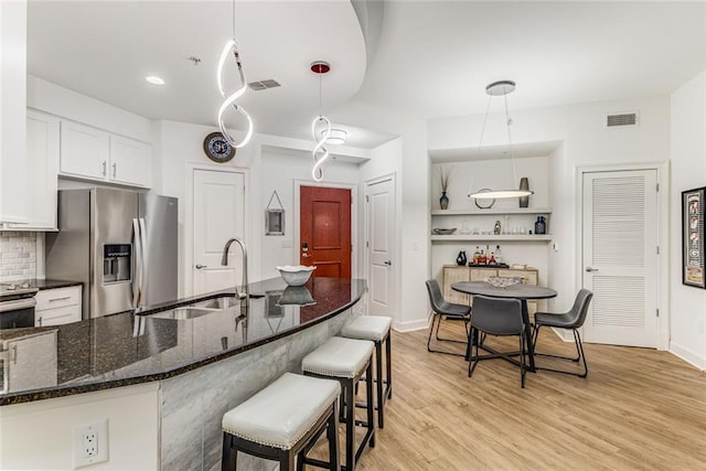 200 River Vista Dr Unit 713, Atlanta, GA 30339 - kitchen with a sink, visible vents, light wood-style flooring, and stainless steel fridge