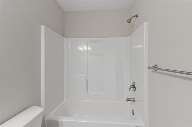 bathroom with bathtub / shower combination and toilet