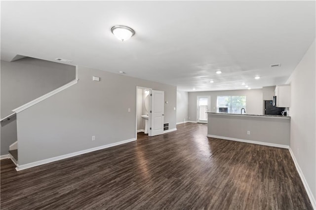unfurnished living room featuring visible vents, baseboards, dark wood-style floors, and recessed lighting