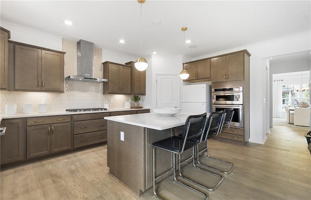 4317 Azalea Ridge Way, Hoschton, GA 30548 - kitchen with wall chimney exhaust hood, stainless steel appliances, light wood-type flooring, ornamental molding, and decorative backsplash