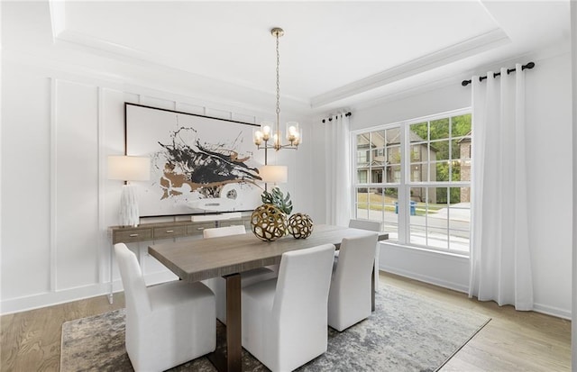 4317 Azalea Ridge Way, Hoschton, GA 30548 - dining room featuring a tray ceiling, light wood-style flooring, a chandelier, and ornamental molding