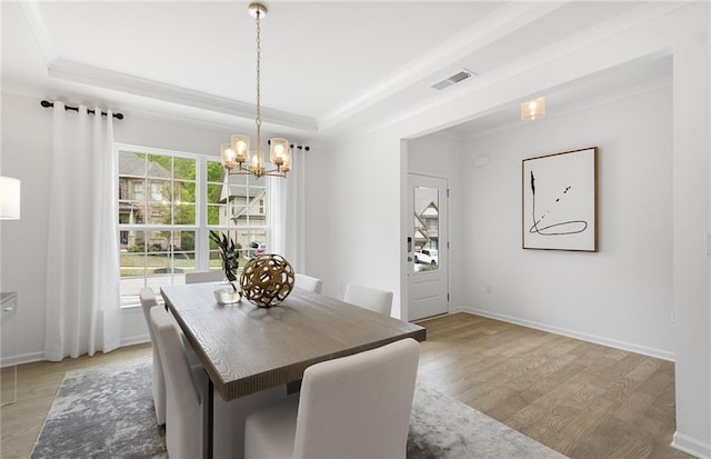 4317 Azalea Ridge Way, Hoschton, GA 30548 - dining area featuring a tray ceiling, light wood-type flooring, a chandelier, and ornamental molding
