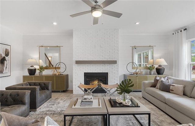 4317 Azalea Ridge Way, Hoschton, GA 30548 - living room featuring a brick fireplace, a ceiling fan, wood finished floors, recessed lighting, and crown molding