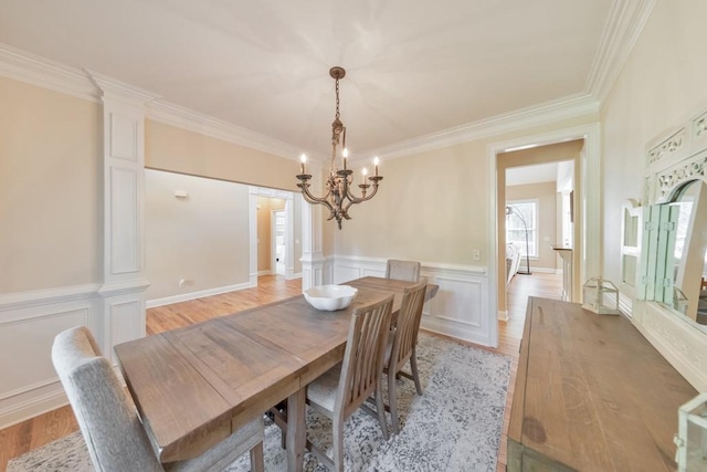 4621 Chartwell Chase Ct, Flowery Branch, GA 30542 - dining room featuring a chandelier, crown molding, light wood-type flooring, a wainscoted wall, and a decorative wall