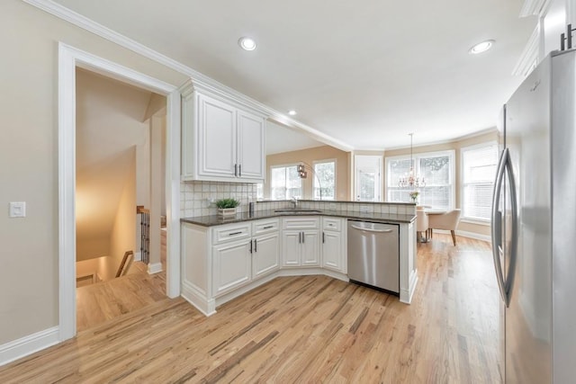 4621 Chartwell Chase Ct, Flowery Branch, GA 30542 - kitchen with stainless steel appliances, a sink, light wood-type flooring, a peninsula, and ornamental molding