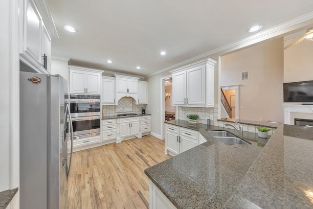 4621 Chartwell Chase Ct, Flowery Branch, GA 30542 - kitchen with stainless steel appliances, ornamental molding, a sink, light wood-type flooring, and backsplash