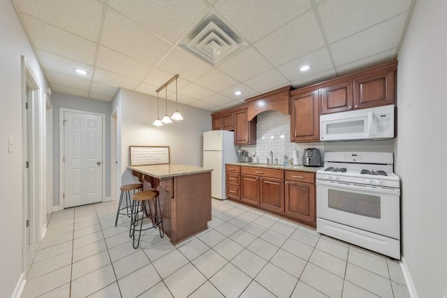 4621 Chartwell Chase Ct, Flowery Branch, GA 30542 - kitchen with white appliances, a sink, a kitchen breakfast bar, light tile patterned flooring, and a paneled ceiling