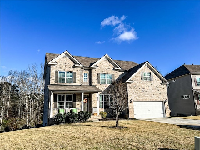 view of front of house featuring covered porch, a garage, and a front yard