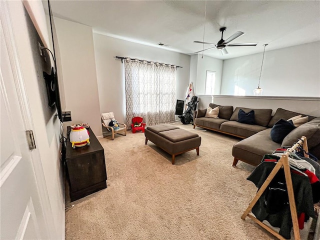 carpeted living room with ceiling fan