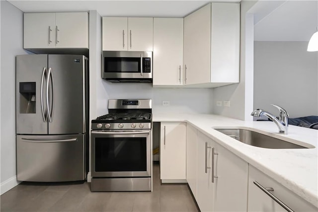 kitchen featuring light tile patterned floors, stainless steel appliances, and a sink