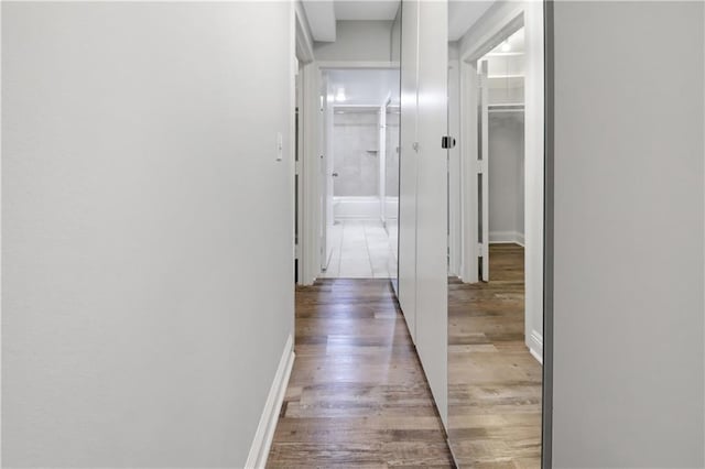 hallway with light wood-style flooring and baseboards