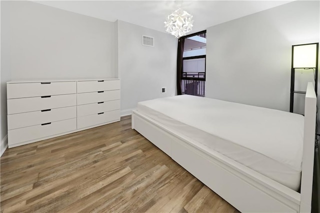 bedroom featuring a chandelier, visible vents, and light wood-style flooring