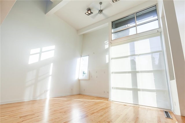 empty room with light hardwood / wood-style floors, high vaulted ceiling, beamed ceiling, and basketball court