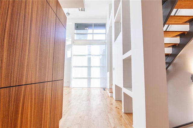 hall with light hardwood / wood-style flooring and floor to ceiling windows