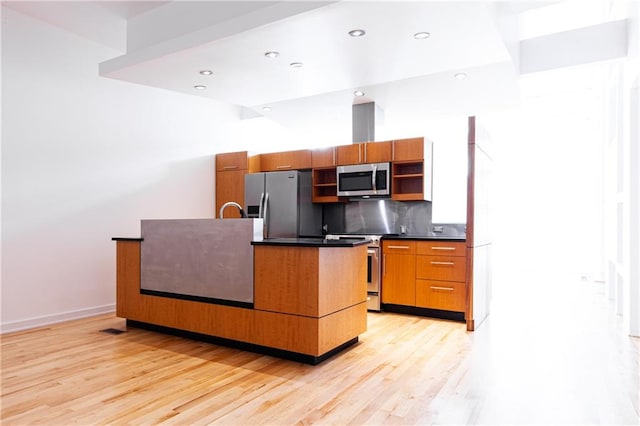 kitchen featuring stainless steel appliances, light hardwood / wood-style floors, and tasteful backsplash