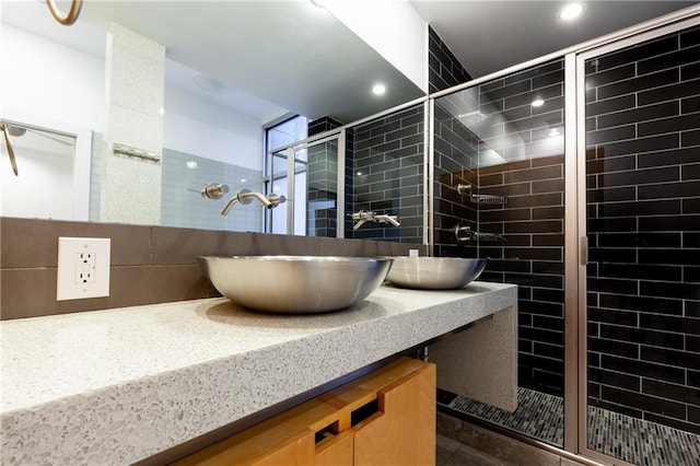 bathroom featuring vanity and a shower with door