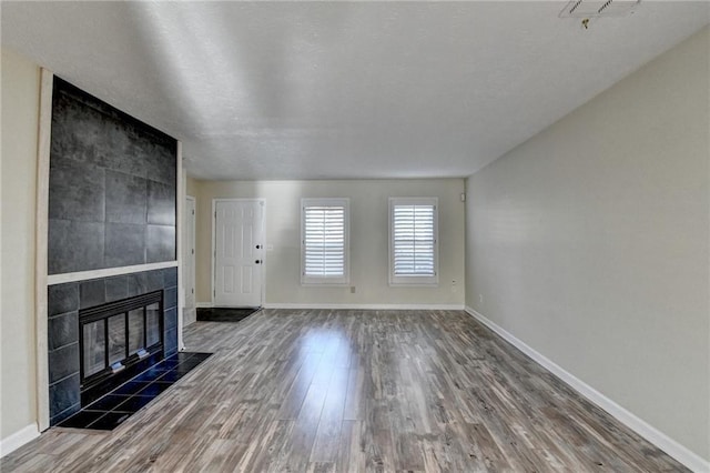 unfurnished living room featuring dark hardwood / wood-style flooring and a fireplace