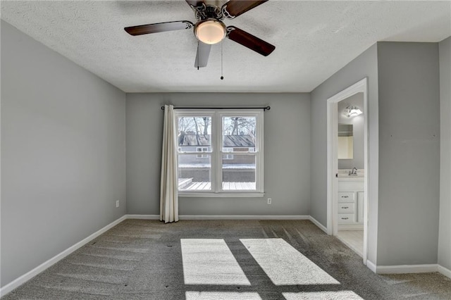 spare room with carpet flooring, ceiling fan, sink, and a textured ceiling