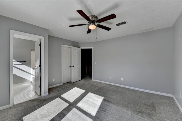 unfurnished bedroom with dark carpet and ceiling fan