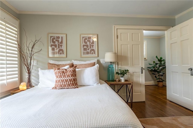 bedroom featuring baseboards, ornamental molding, and wood finished floors