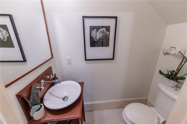 half bath with vanity, toilet, and baseboards