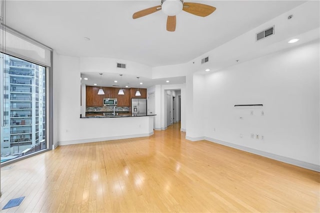 unfurnished living room featuring light hardwood / wood-style floors and ceiling fan