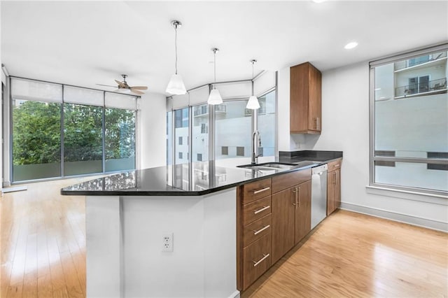 kitchen featuring kitchen peninsula, light wood-type flooring, dishwasher, pendant lighting, and sink