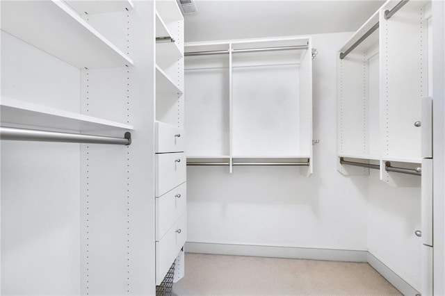 walk in closet featuring light colored carpet