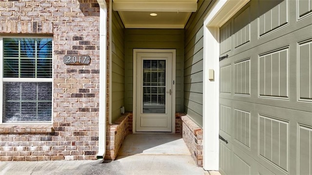 view of exterior entry featuring brick siding