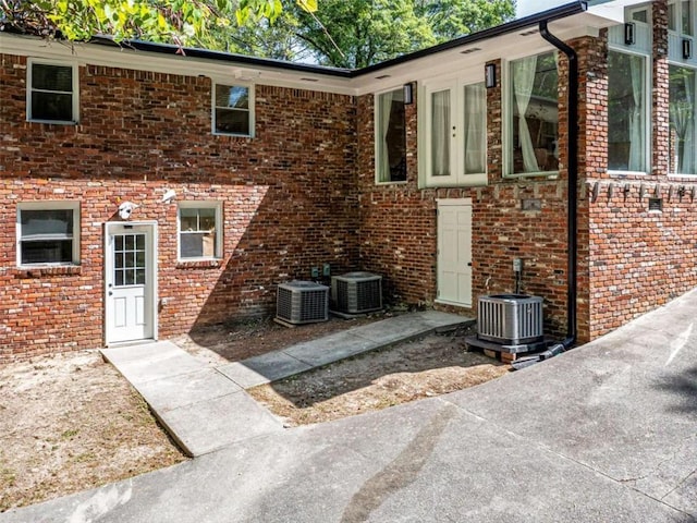 exterior space with central AC unit and brick siding