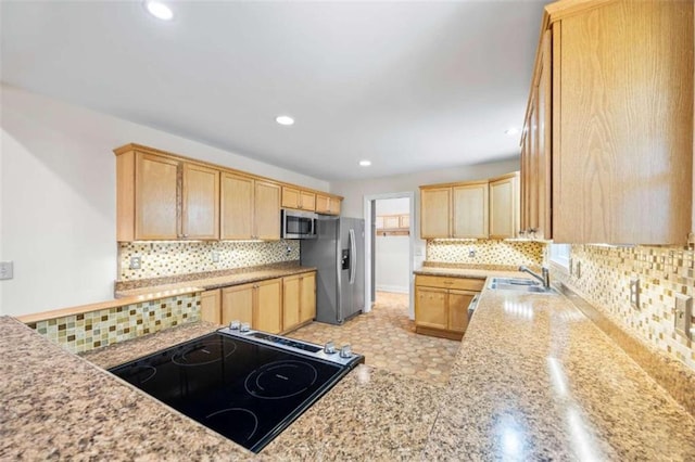 kitchen featuring appliances with stainless steel finishes, sink, light brown cabinetry, backsplash, and light stone counters