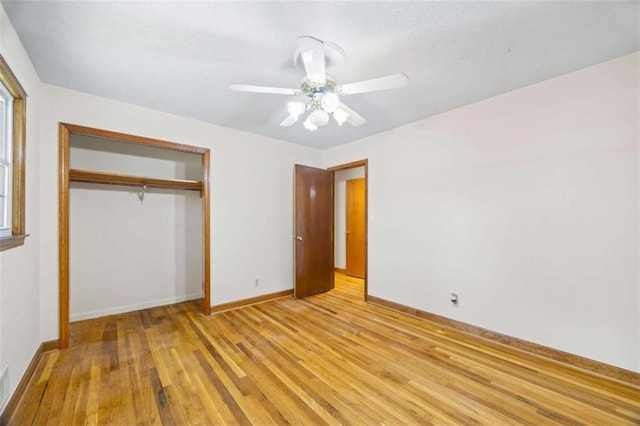 unfurnished bedroom with light hardwood / wood-style flooring, a closet, and ceiling fan