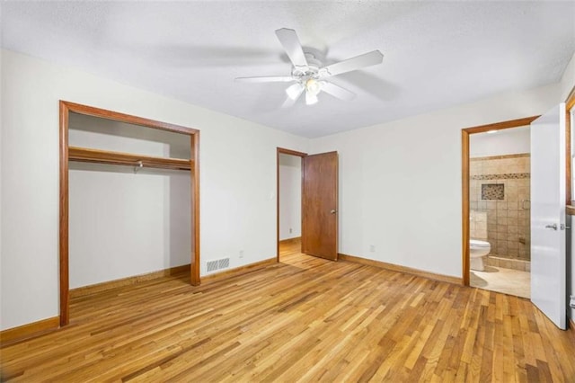 unfurnished bedroom with ensuite bath, a closet, light hardwood / wood-style floors, and ceiling fan