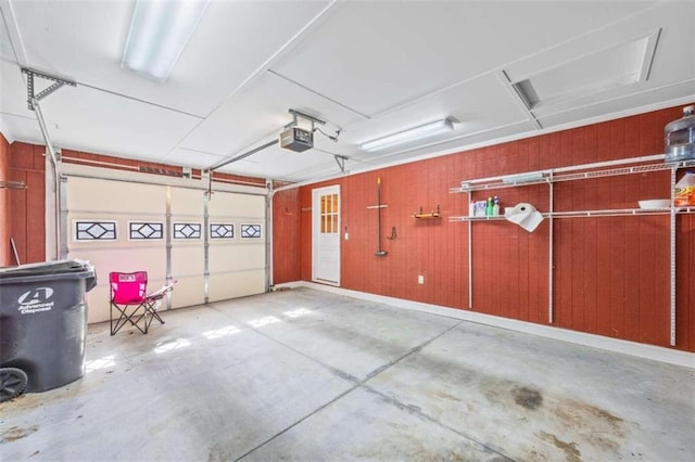 garage with a garage door opener and wood walls